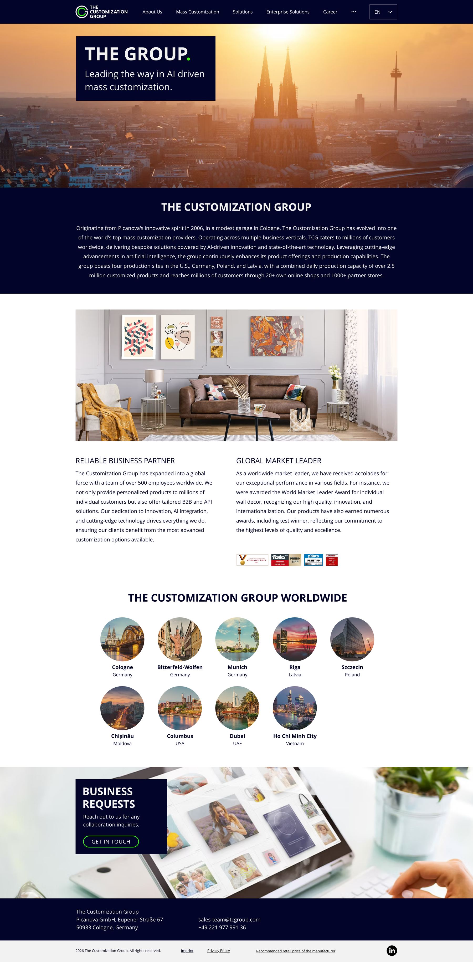 The About page: a Cologne skyline hero headed The Group, a dark paragraph on the company history, an interior still above reliable-partner and market-leader columns with award marks, then nine circular location portraits from Cologne to Ho Chi Minh City, and a business-requests band.