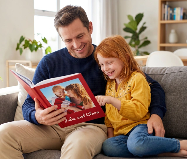 Personalised hardcover photo book lying on a bed of warm-toned printed pages
